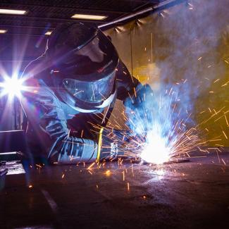 A welder working on a car.